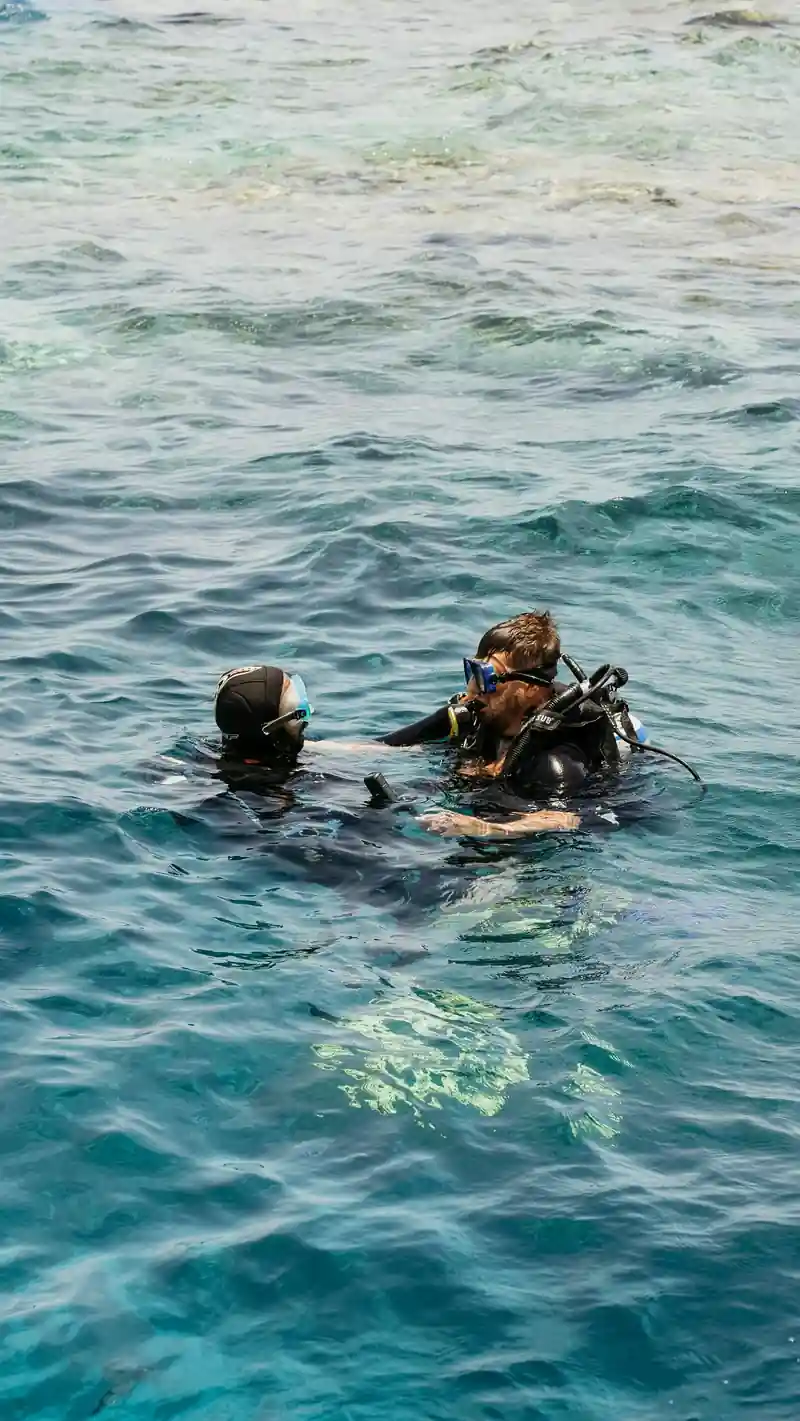 Two divers at the surface in clear turquoise water