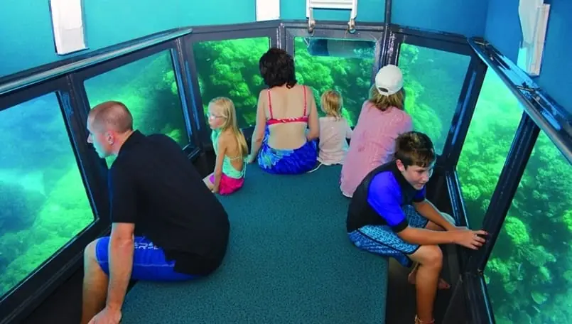 A family looking out at the reef through the submarine's viewing windows
