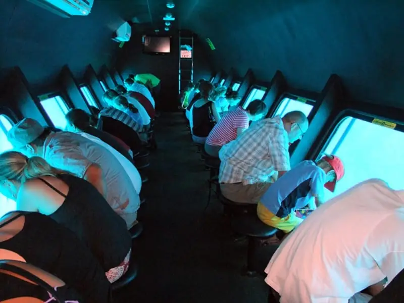 Passengers at the round windows along the submarine's cabin