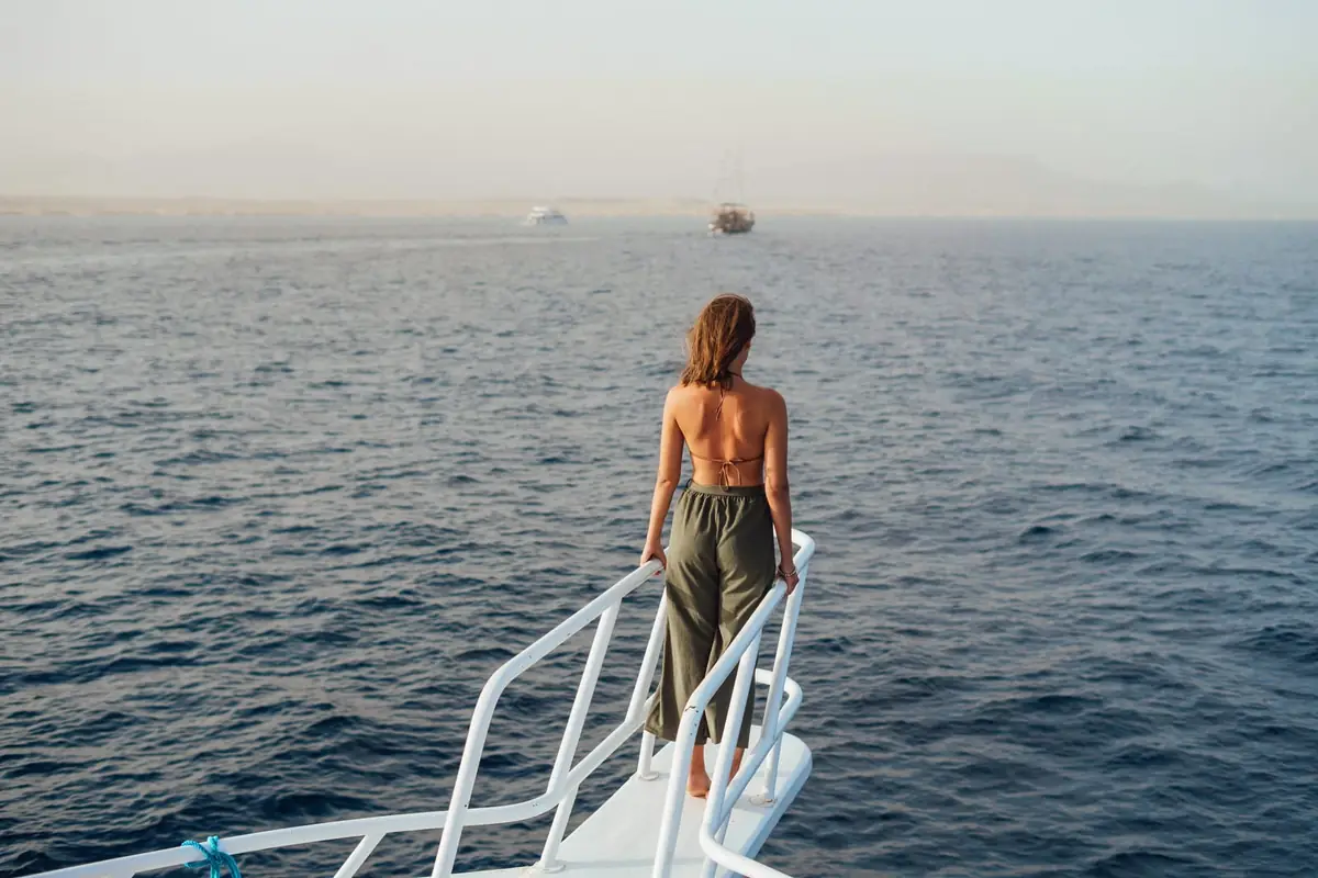 A guest at the bow rail looking out over a calm sea