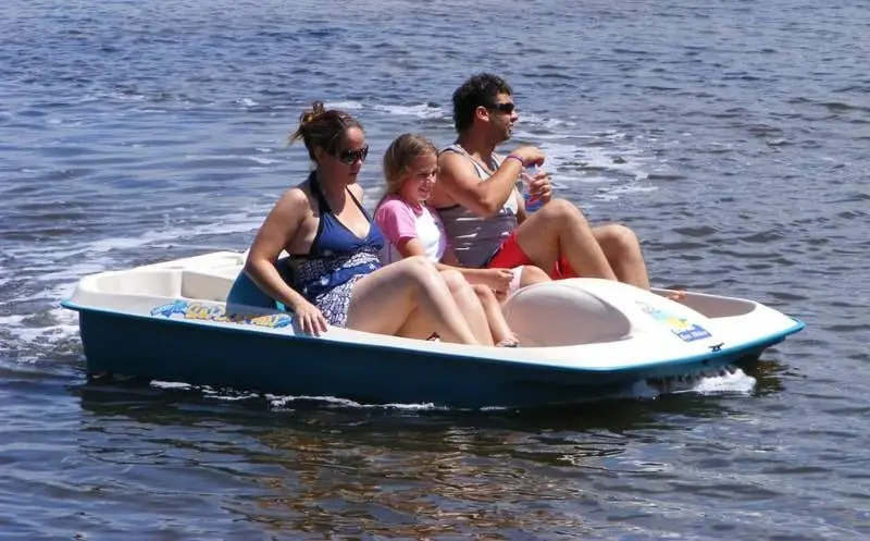 A family pedalling a pedal boat across open water