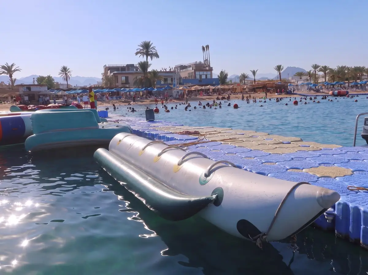 A banana boat moored at the pontoon, with the beach and swimmers in the distance