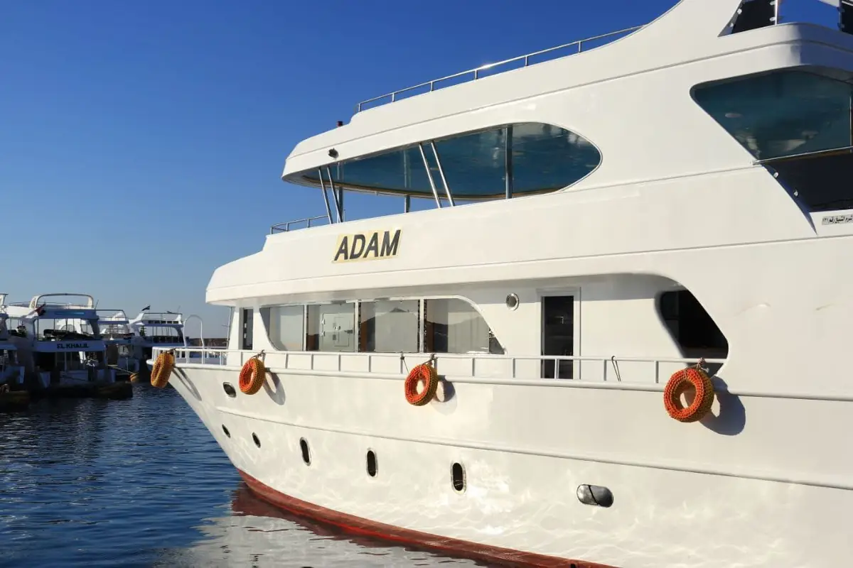 The bow of a white day yacht moored at the marina quay