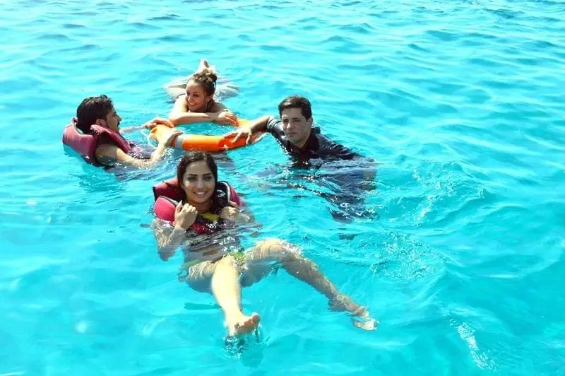 Swimmers in life jackets floating together in clear turquoise water