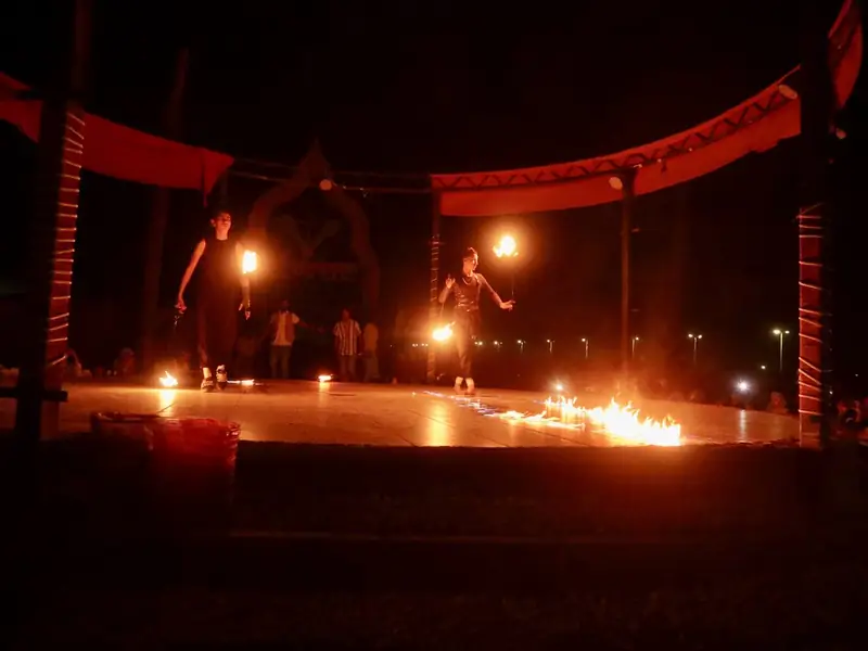 Torches and low tables at a Bedouin camp after dark.