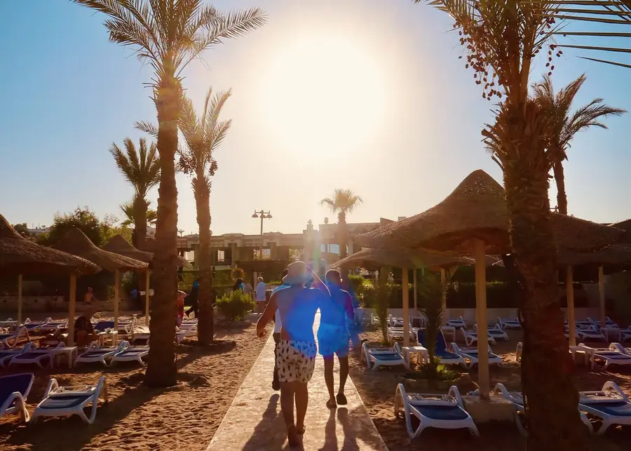 The walk down to the beach through the palms — the last leg of the hotel pickup.